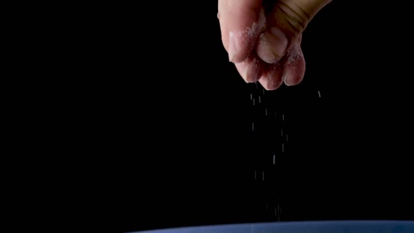 Man's hands are sprinkling salt on food on a black background	 Royalty-Free Stock Footage #1103253801