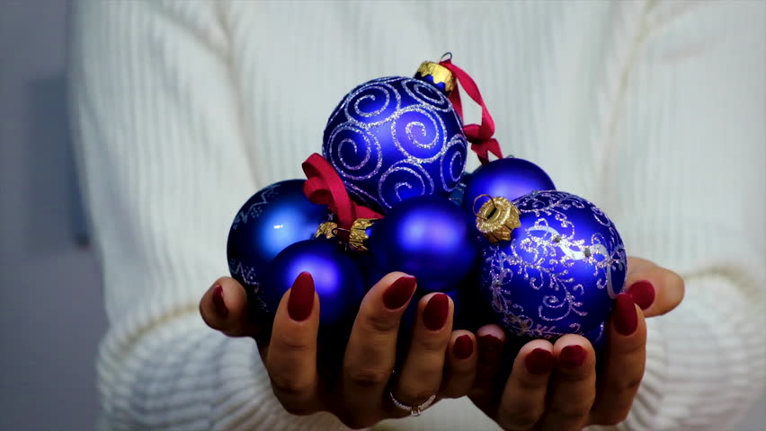 Christmas decorations in the hands of a woman. Selective focus. People.
