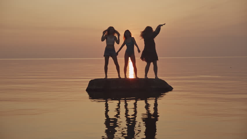 happy friends hippie family dancing on beach. party by lake, woman dancing. happy girls dancing on beach. Slow motion. beautiful girls having fun listening to music. teens girlfriends holiday disco. Royalty-Free Stock Footage #1103254329