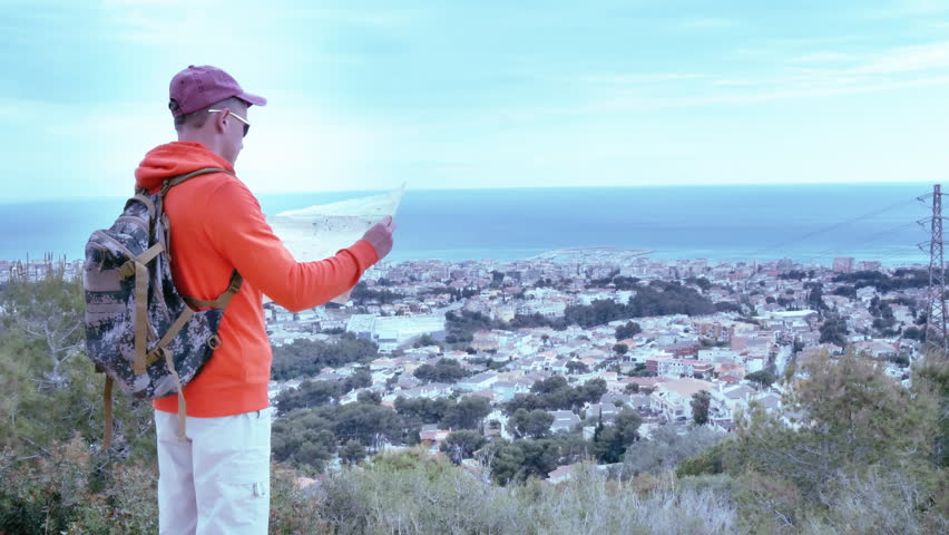 City Exploration: Adventurous Man Standing atop, Studying City Map