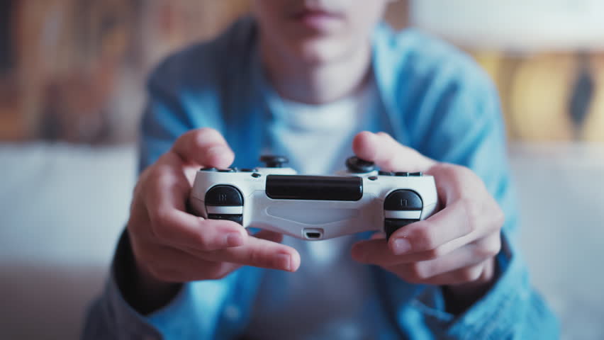 Young Gamer: Teen Boy Immersed in Console Gaming, Cinematic Shot of Sofa Gameplay with Joystick Close-Up Royalty-Free Stock Footage #1103256959