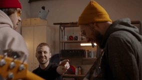 Friends talking and laughing during their rock band rehearsal inside a garage. Vocals, guitars and drums. Shot with 2x anamorphic lens - Powered by Shutterstock - Get 15% off with code: PIKWIZARD15