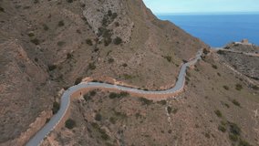 Professional bike athletes descending fast on road bicycles with stunning sea view.Cycling training.Cycling down curvy road.Motivational aerial video.Alicante, Spain
