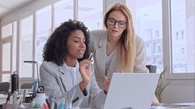 Two businesswoman working together using laptop pc, sitting at table and discussing a project. Small creative diversity team of African American and blond females executives meeting work in office. - Powered by Shutterstock - Get 15% off with code: PIKWIZARD15