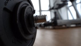 an athlete collects a dumbbell in the gym