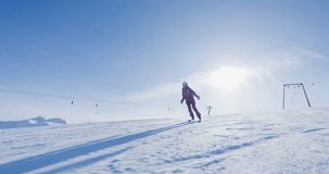 Girl skier skiing on slopes in a mountain winter ski resort. Slow motion video 50fps recorded with cinema camera.