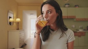 Close up, young woman drinking orange juice while sitting in the kitchen - Powered by Shutterstock - Get 15% off with code: PIKWIZARD15