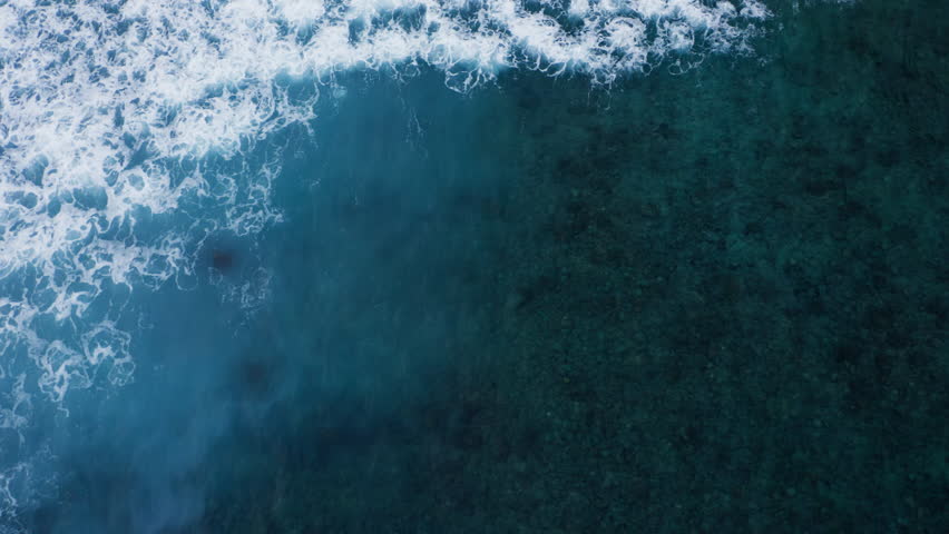 Beautiful texture of ocean waves with white wash passing over reef . Aerial top view footage of fabulous sea tide. Drone filming breaking surf with foam in Indian ocean. low tide transparent water.  | Shutterstock HD Video #1103277281