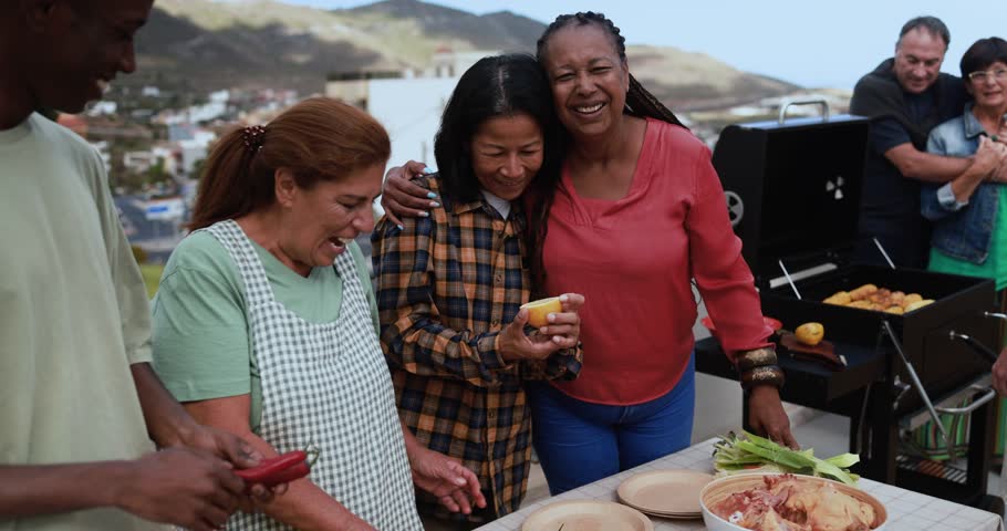 Multi generational people doing barbecue during weekend day at home's rooftop preparing food - Multiracial friends having fun smiling in front of camera Royalty-Free Stock Footage #1103279297