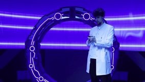 Caucasian man in white uniform testing new spacecraft equipment and making research. Technical engineer switching on neon lighting within a spacecraft. High quality 4k footage