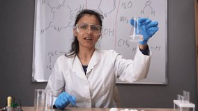 teacher-blogger records live training video, shows chemical reaction of different elements, holds flask in his hands and demonstrates result. chemistry lesson online. Blog concept. webcam view. pov