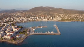 4K aerial - a bird's eye view video (Ultra High Definition) of Nea Artaki port. Sunny summer sunset on Euboea island, Greece, Europe. Colorful Aegean seascape. Traveling concept background.