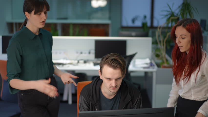 Man with angry facial expression sitting at computer in office listening dissatisfied women talking gesturing in slow motion. High angle view portrait of overburdened Caucasian manager with colleagues | Shutterstock HD Video #1103289005