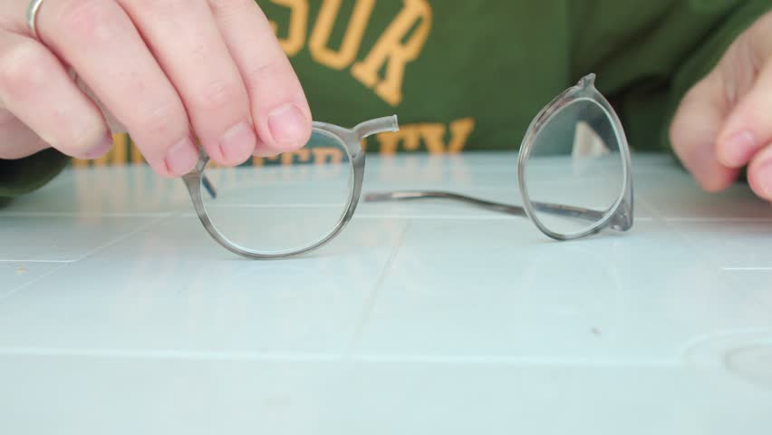 close-up, a person repairs, hands glue glasses for myopia or farsightedness, a fragile structure. 