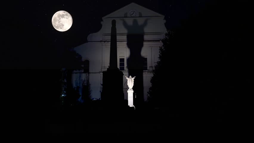 Jesus Christ statue with the huge shadow on the back side of St. Louis Cathedral by Full Moon. New Orleans, Louisiana, USA