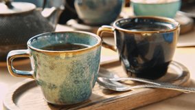 Brewing and Serving Tea. Teapot Pouring Green Tea in Blue Ceramic Cup on Wooden Cafe Table. Two Pottery Handmade Mugs Early in the Morning. Trendy Authentic Porcelain Set. Breakfast Concept. Tea Time. - Powered by Shutterstock - Get 15% off with code: PIKWIZARD15