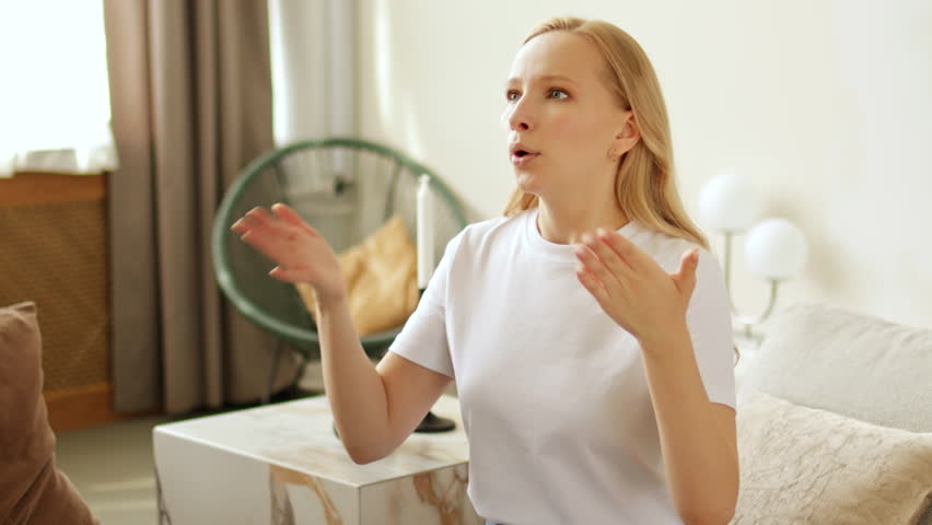 Overheated sweating woman feeling hot. Suffering from high temperature at home and heat without air-condition or climate control system. Breathing deeply and waving hands to cool down Royalty-Free Stock Footage #1103291317