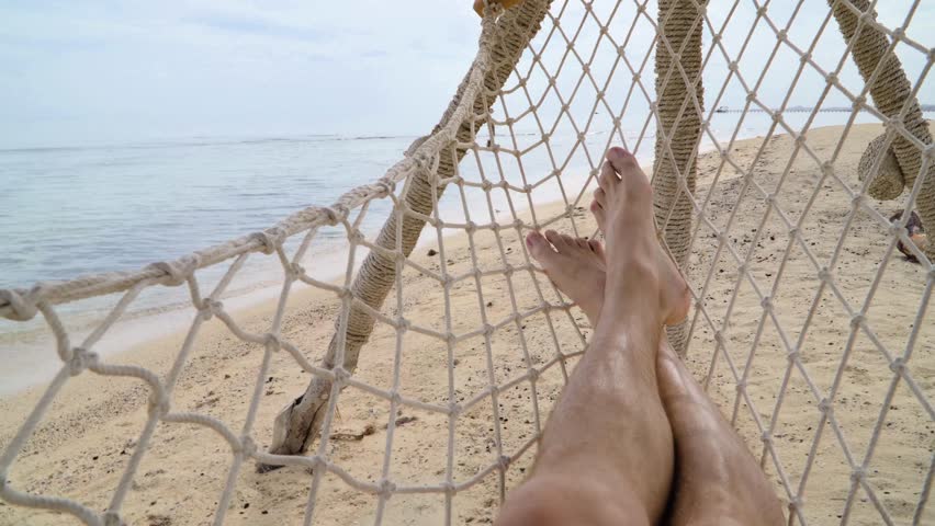 On the shore of the Red Sea in Egypt, POV point of view, man legs in a hammock on a sunny summer day in the shade of palm trees
 Royalty-Free Stock Footage #1103294431