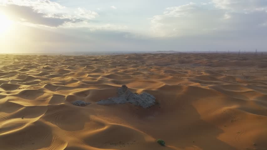 Drone around a lonely rock among the sandy desert