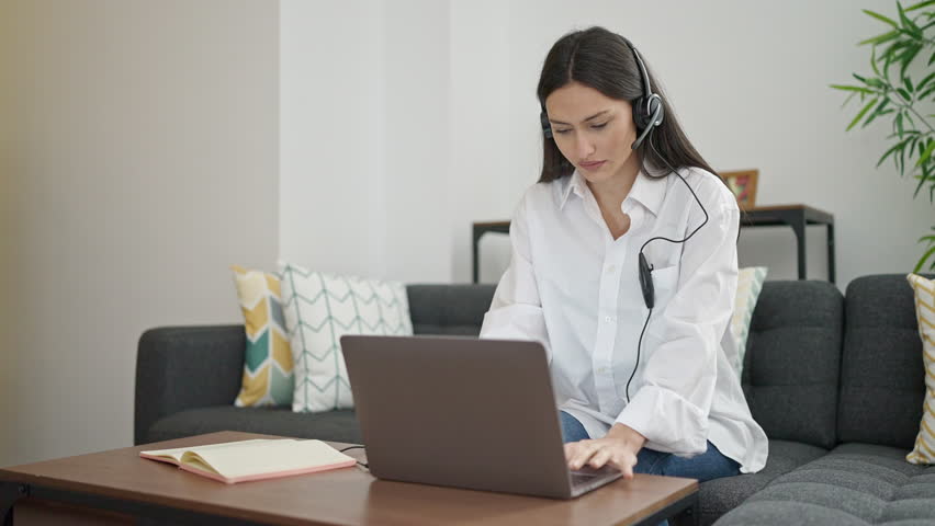 Young beautiful hispanic woman call center agent working at home