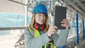 Young blonde woman builder smiling confident having video call at street