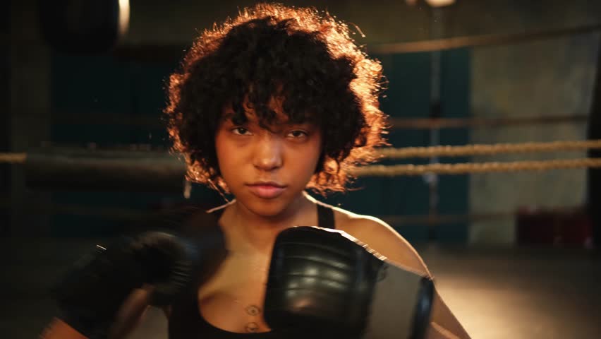 Outcry independent girl power. Angry african american woman fighter with boxing gloves looking serious aggressive to camera standing on boxing ring. Strong powerful girl looking concentrated straight Royalty-Free Stock Footage #1103308473
