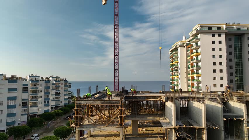Builders preparing the floor of the house for pouring concrete aerial view
Construction site on the shores of the Mediterranean Sea, a crane lifts the metal structure 4 K