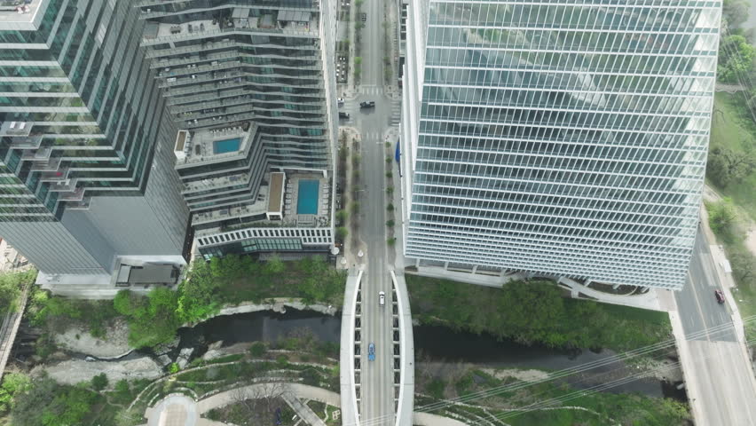 4k drone flying above cars driving by road in Austin downtown on sunny summer day. Aerial cityscape rooftops view. Beautiful background for transportation real estate business, Austin city, Texas USA