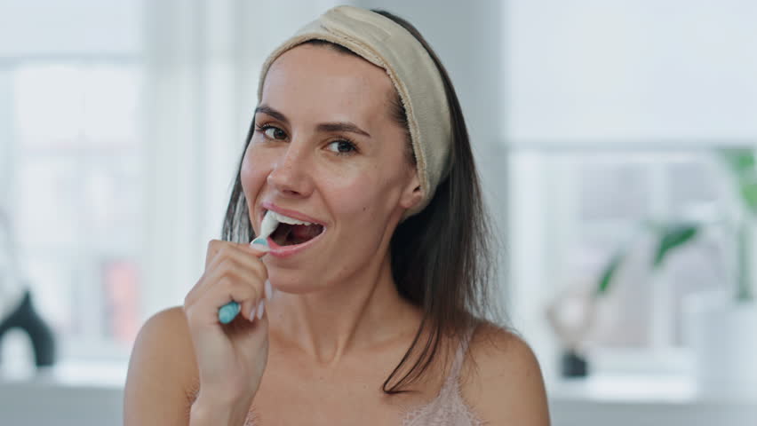 Pov cheerful model brushing mouth at bathroom. Close up happy woman holding toothbrush enjoying morning dental care routine in bath. Portrait fresh lady cleaning teeth having daily procedures at home Royalty-Free Stock Footage #1103315831