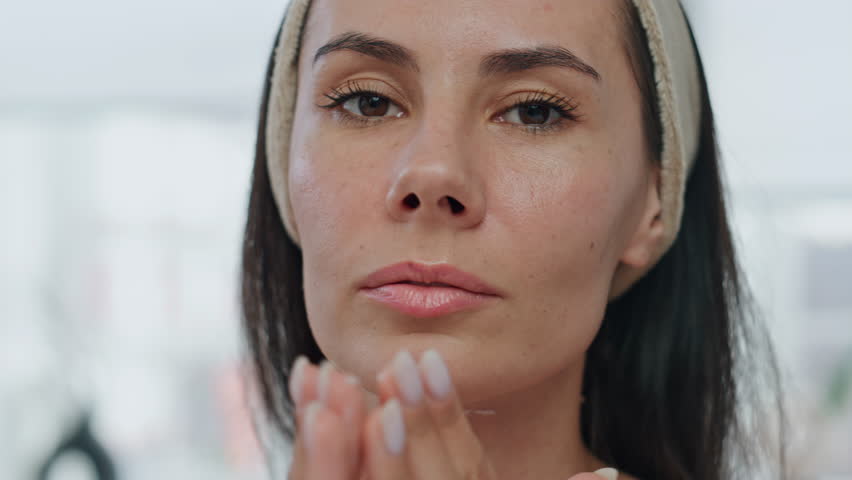 Portrait woman moisturize face cream indoors. Pov view relaxed lady applying beauty product moisturizing skin at morning. Brunette model pampering at home closeup. Feminine daily procedures concept Royalty-Free Stock Footage #1103315911