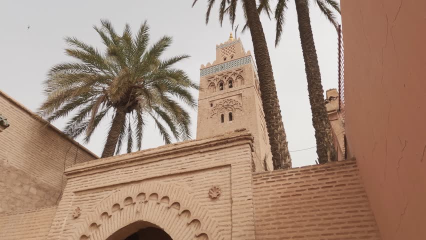 View of Minaret framed by palm trees at Koutoubia Mosque in Marrakesh, Morocco | Shutterstock HD Video #1103323889