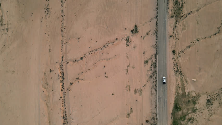 Aerial video of a vehicle traveling on a road in a desert area, israel