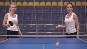two women in white jerseys are playing table tennis. slow motion video. High quality Full HD video recording
