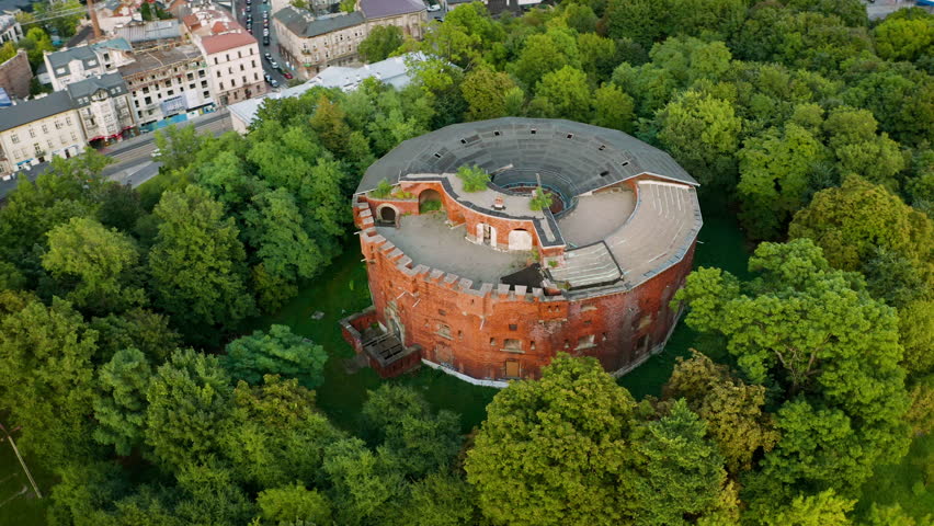 Aerial view of alone, rounded, brick fortress in forest in Krakow, Poland
