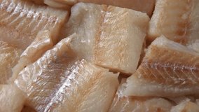 Raw fish fillet is spinning. Top view. Slices of fresh whitefish. Full frame. Sashimi rotation. Close up. Marine market. Video for sale. Cod, pollock loin steaks. Pangasius, tilapia pieces background.