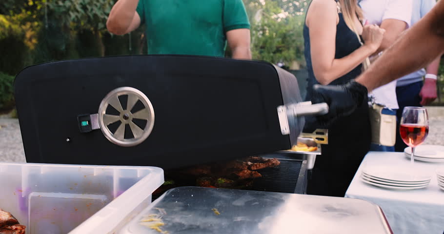 Picnic with friends. Summer barbecue with friends. Grilled pork, beef, lamb, chicken and vegetables. Close-up shot of opening the grill. BBQ meat grill for party Royalty-Free Stock Footage #1103331839