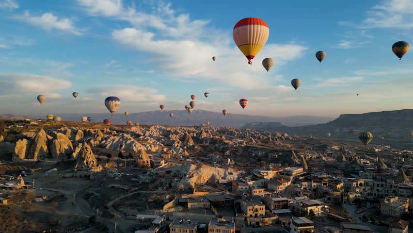 Drone - Hot Air Balloons, Cappadocia, Turkey 2023 - Slowly flying up towards red and white air balloon high with others over the city | Shutterstock HD Video #1103338451