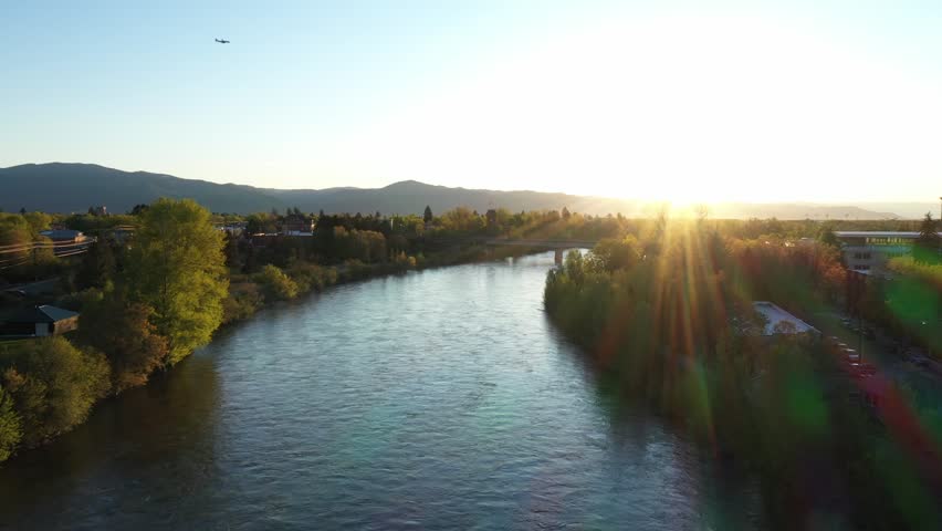 An aerial view of Clark Fork River flowing through Missoula city surrounded by mountains
