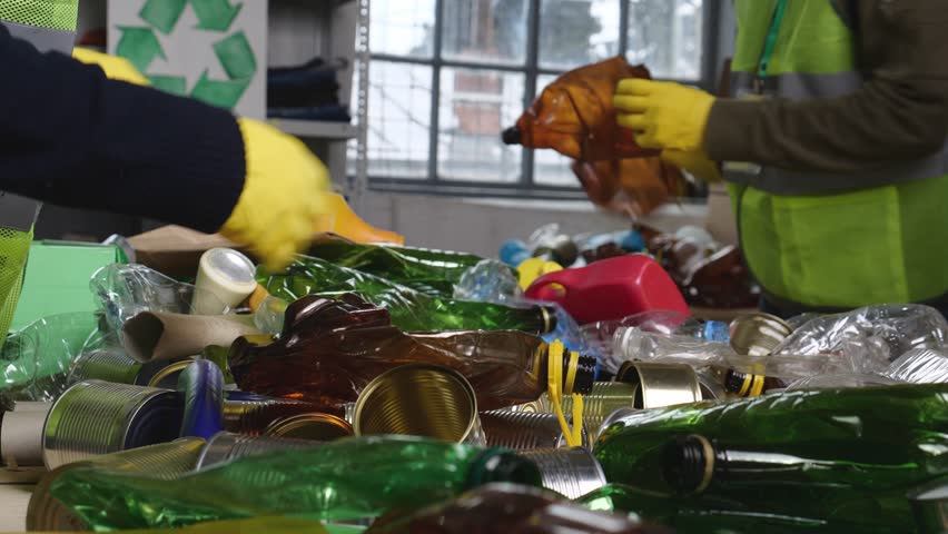 Recycling Center. Glass, cans and plastic bottles are inspected, sorted, baled and trucked to mills and plants where the recycled material is made into something new | Shutterstock HD Video #1103355999