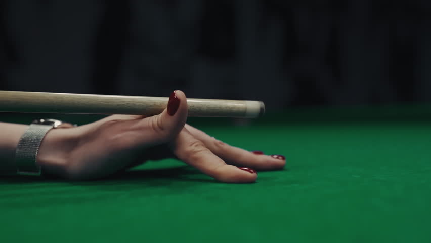 A woman's hand with cue aiming on billiard ball at green table | Shutterstock HD Video #1103356367