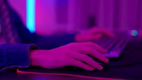 RGB neon light. finger tapping on neon backlit gaming mouse, cybersport. Professional esport gamers. Gamer playing a video game with keyboard. Computer hands typing on keyboard browsing online.
