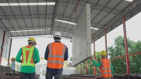 Team young asian engineer man walking while crane lifting precast concrete wall panel with professional at industrial factory, worker working with construction site, industry and transport concept. - Powered by Shutterstock - Get 15% off with code: PIKWIZARD15