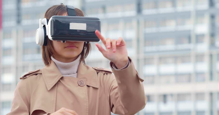 Teenage girl wearing VR glasses, immersed in a virtual world. Potential of cutting-edge technology in the heart of the metropolis. Royalty-Free Stock Footage #1103362269