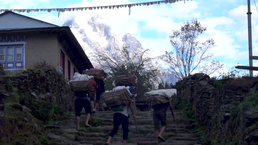 Unidentified Hikers on the way to Himalaya, 2023
five porters carrying heavy load up stairs with himalaya mountain in background
 Royalty-Free Stock Footage #1103369129