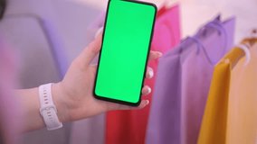Woman with Green Screen Chroma Key Smartphone in mall. Woman Person using Internet, Social Media, Online Shopping with Mobile Phone Device. Focus on Display, Hand 4K