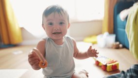 baby play toy on floor at home. happy family kid dream concept. baby smiling waving his hands in kindergarten. baby holding a toy looking at mom. child play in lifestyle kindergarten - Powered by Shutterstock - Get 15% off with code: PIKWIZARD15