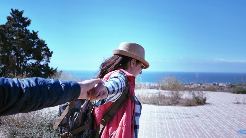 Adventurous couple hiking uphill together, hand in hand, exploring the great outdoors with joy