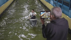 An elderly coach shoots a video on a tablet. Slow-motion video. canoe slalom. High-quality FullHD video recording