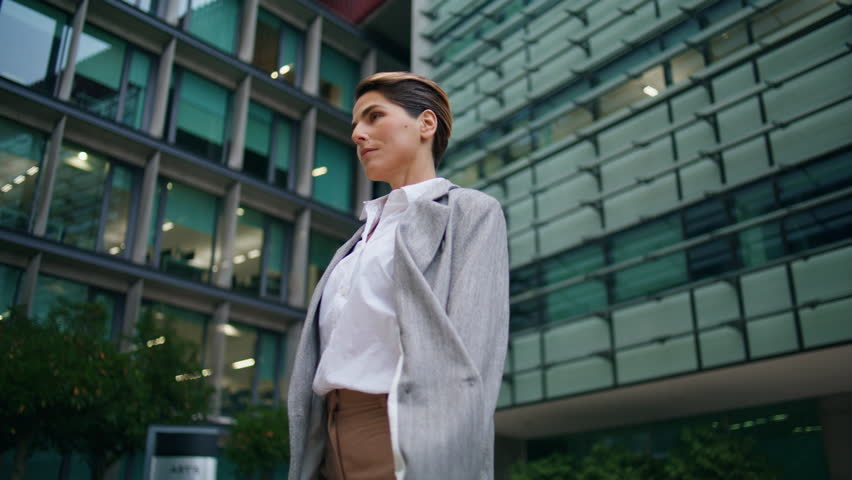 Successful ceo walking downtown street. Confident middle aged businesswoman going corporate client meeting at contemporary urban building. Pensive financial manager female leader look camera in suit. Royalty-Free Stock Footage #1103380411
