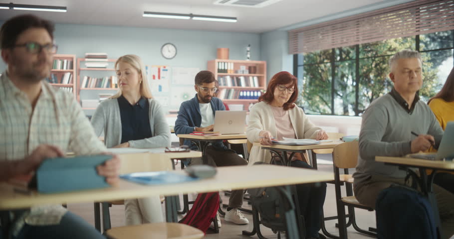 Diverse Mature Students Learning in Classroom, Using Laptops and Writing in Notebooks. Senior Female Motivated to learn New Skills During an Adult Education Course in School Royalty-Free Stock Footage #1103381451